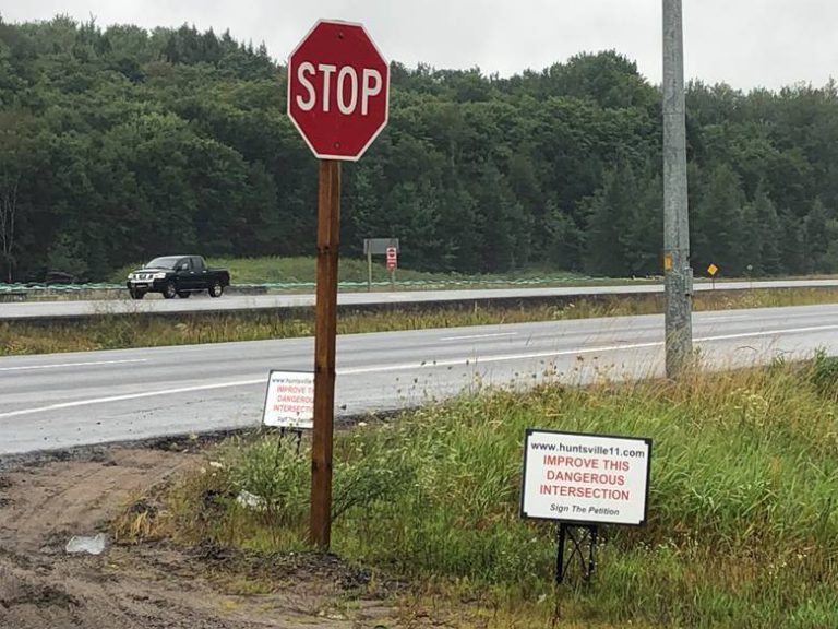 Highway 11 overpass advocates place warning signs along route